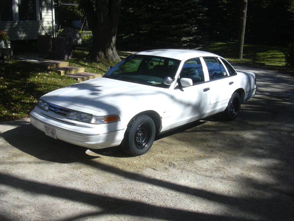 1997 Ford Crown Victoria, white, black steel wheels, parked on driveway
