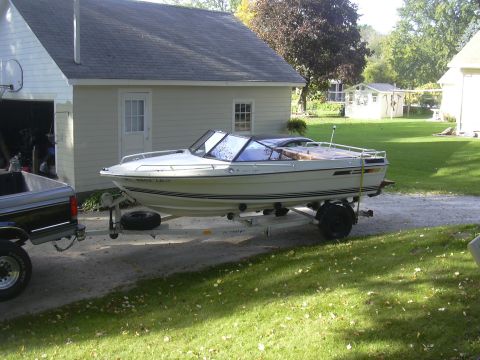 1979 Four Winns 170 Horizon - A 1979 Four Winns 170 Horizon boat is seen on a trailer in a residential driveway.
