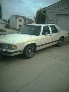 1985 Ford Crown Victoria LTD - White 1985 Ford Crown Victoria LTD sedan in a driveway next to a garage.