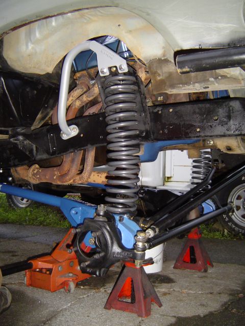 1978 Ford Bronco - Custom suspension modifications are visible on the underside of the vehicle, supported by jack stands.