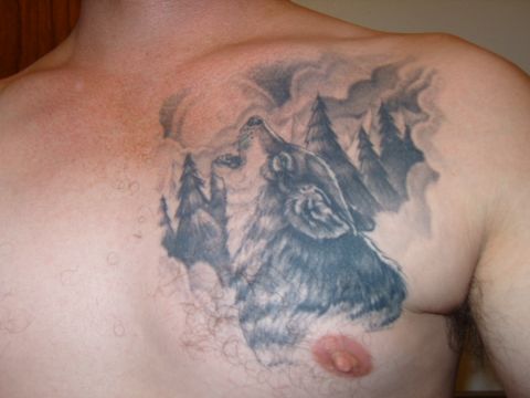 1989 Ford Bronco - A chest tattoo depicts a wolf howling at the moon amidst a backdrop of pine trees.
