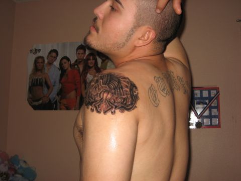 1993 Ford Bronco - A man poses for a photo, displaying tattoos on his shoulder and back, with a poster on the wall.
