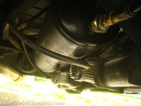 1994 Chevrolet Silverado 3500 - Underside view of an air suspension compressor and tank with braided hoses attached.