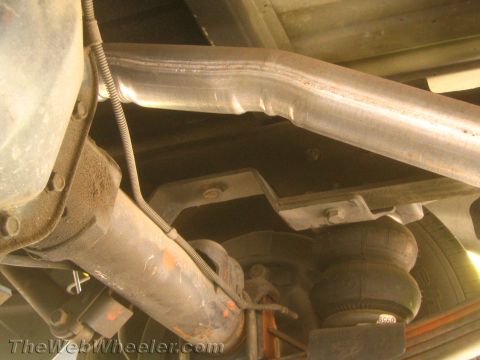 1994 Chevrolet Silverado 3500 - Underside view of a vehicle's suspension system, an exhaust pipe and an air spring.