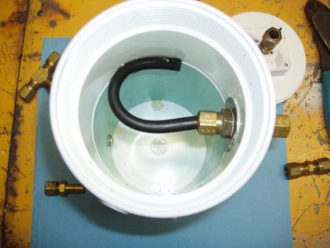 2001 Ford Excursion - A close-up view of a DIY PVC pipe assembly with various brass fittings and a flexible hose.