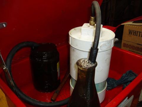 2001 Ford Excursion - A fuel filter and collection setup is shown within a red basin, with a box labeled 'WHITE BIODEG' in the background.