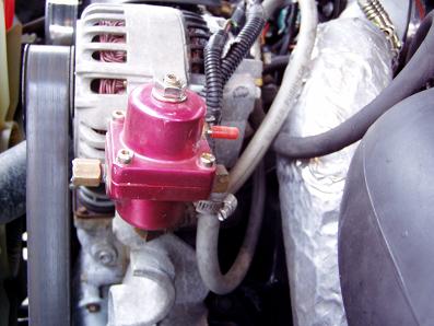 2001 Ford Excursion - A red aftermarket fuel pressure regulator is shown mounted on an engine.