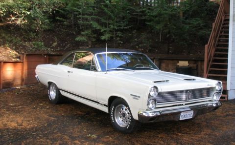 1972 Ford Ranchero - White 1967 Mercury Cougar parked outdoors with a wooden fence and stairs in the background.
