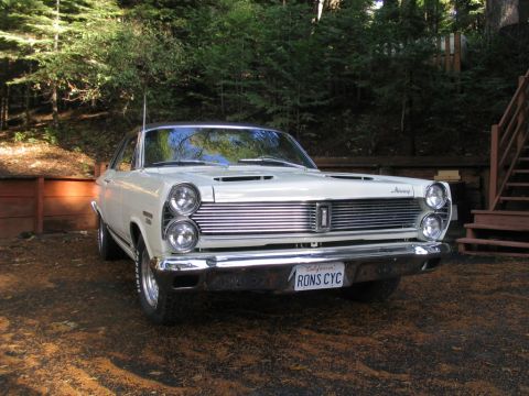 1972 Ford Ranchero - A white 1967 Mercury Cougar XR7 is parked outdoors, its distinctive grille and dual headlights.