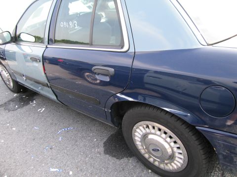 1991 Ford LTD Crown Victoria - Side view of a 1991 Ford Crown Victoria LTD with visible damage and mismatched paint on doors.