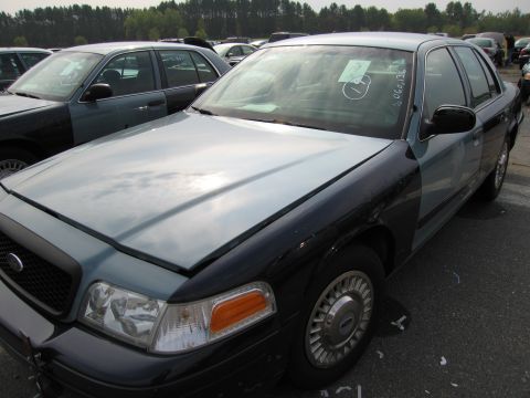1991 Ford LTD Crown Victoria - A two-tone sedan parked in a lot with other vehicles, a sticker on the windshield.