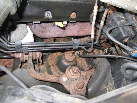 1991 Ford LTD Crown Victoria - Close-up view of corroded engine parts, including exhaust manifold and suspension components.