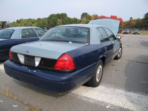 1991 Ford LTD Crown Victoria - A two-tone blue and grey sedan is parked with its hood open, alongside another similar vehicle.