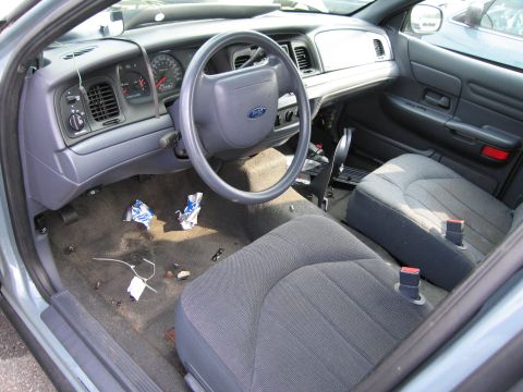 1991 Ford LTD Crown Victoria - The interior of a Ford Crown Victoria shows a messy floor with trash and a worn dashboard.