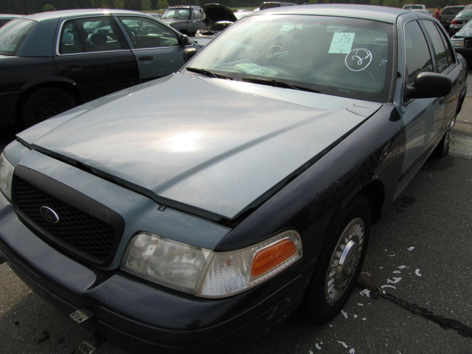 1991 Ford Crown Victoria LTD front end, hood is light gray, body is dark blue. Another Crown Victoria is parked to the left