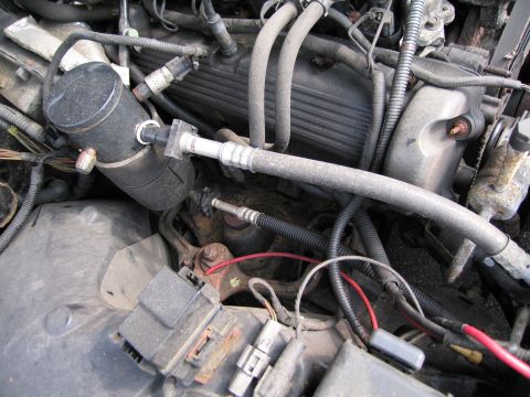 1991 Ford LTD Crown Victoria - Close-up view of an engine bay, showing various hoses, wires, and mechanical parts.
