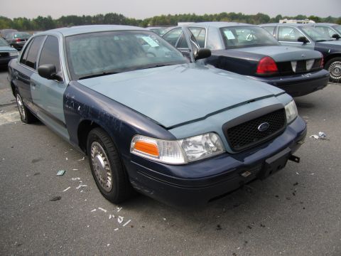 1991 Ford LTD Crown Victoria - A two-tone Ford Crown Victoria sits in a parking lot with other vehicles.