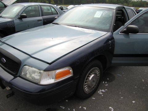 1991 Ford LTD Crown Victoria - 1991 Ford Crown Victoria LTD, front quarter view, with driver's door ajar and another similar vehicle visible behind.