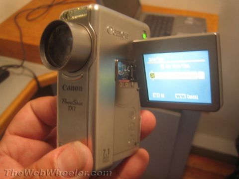 1968 Ford Mustang - A Canon PowerShot TX1 camera is held in a hand, displaying its menu on the flip-out screen.