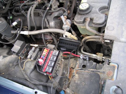 1991 Ford LTD Crown Victoria - Close-up view of the engine bay, focusing on the fuse box and associated wiring.