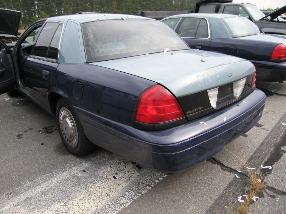 Rear view of a blue and light blue Ford Crown Victoria parked next to another Crown Victoria