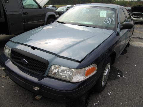 1991 Ford LTD Crown Victoria - A two-tone Ford Crown Victoria is parked outside with other vehicles in the background.