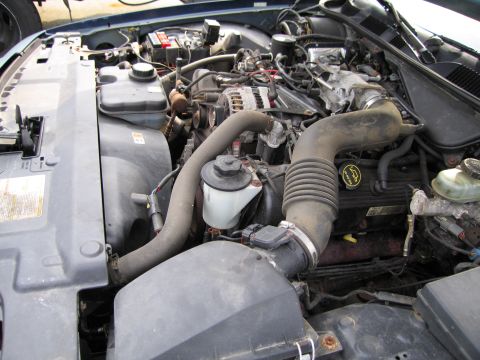 1991 Ford LTD Crown Victoria - View of the engine bay, showing various hoses, the air intake system, and engine components.