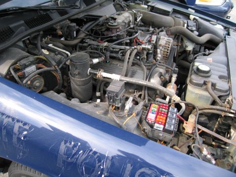 1991 Ford LTD Crown Victoria - The engine compartment of a 1991 Ford Crown Victoria LTD is visible, with the hood open.