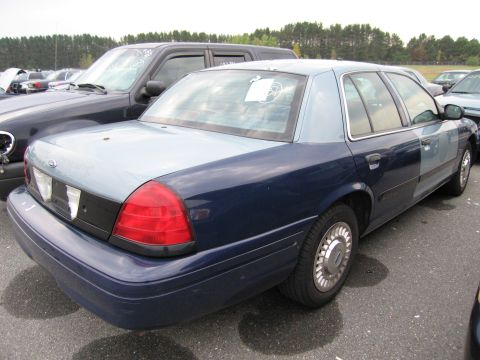 1991 Ford LTD Crown Victoria - A two-tone blue Ford Crown Victoria is parked in an outdoor lot with other vehicles.