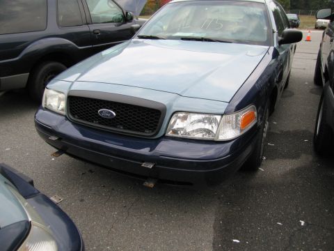 1991 Ford LTD Crown Victoria - Two-tone Ford Crown Victoria parked outdoors, showing front grille and headlights.