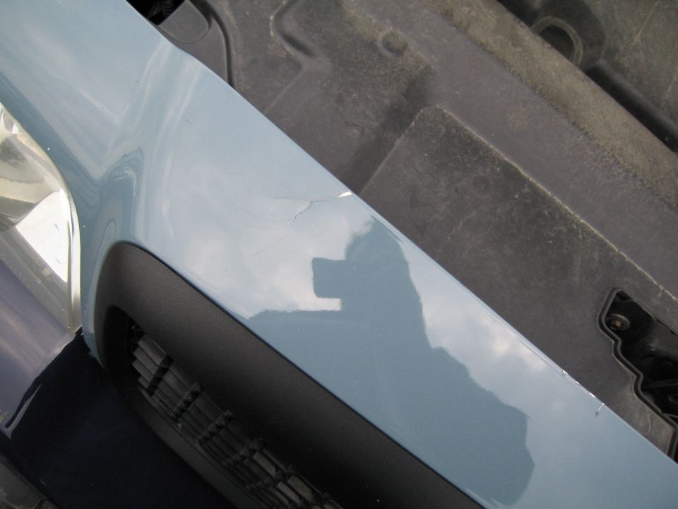 Light blue fender with crack and reflection of photographer