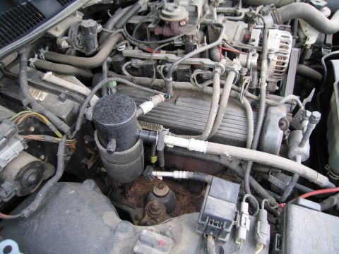 1991 Ford LTD Crown Victoria - Close-up view of a vehicle's engine bay, showing various mechanical parts and wiring.