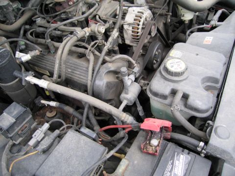 1991 Ford LTD Crown Victoria - Close-up view of a car's engine compartment, showing various mechanical components and wiring.