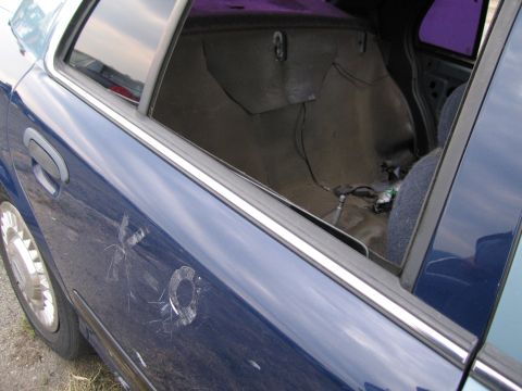 1991 Ford LTD Crown Victoria - Interior view of a blue sedan showing damage to the door panel and exposed wiring.