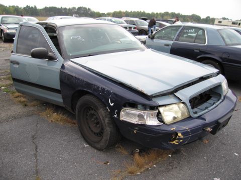 1991 Ford LTD Crown Victoria - A damaged two-tone Ford Crown Victoria sits in a lot with other vehicles.