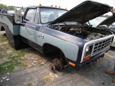 1991 Ford LTD Crown Victoria - This Dodge Ram pickup truck is missing its front wheels and has its hood open, revealing the engine bay.