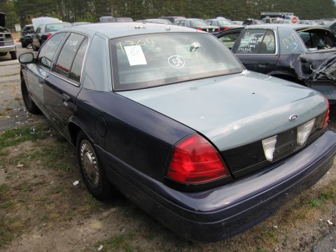 1991 Ford LTD Crown Victoria - This Ford Crown Victoria is parked in a junkyard, showing its rear end and side profile.