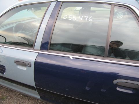 1991 Ford LTD Crown Victoria - The interior of a two-tone police car is visible through the side window, with a number written on the glass.