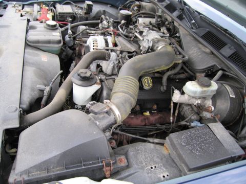 1991 Ford LTD Crown Victoria - Close-up view of a car's engine bay, showing various mechanical components.