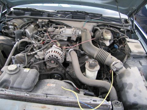 1991 Ford LTD Crown Victoria - The engine compartment of a vehicle is shown with various components and wiring.