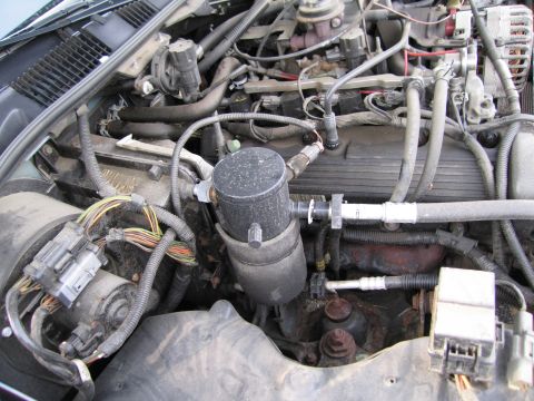 1991 Ford LTD Crown Victoria - Close-up view of a vehicle's engine bay, showing various hoses, wires, and engine components.