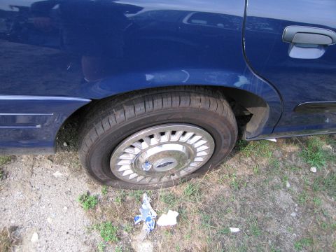 1991 Ford LTD Crown Victoria - Rear wheel and side door of a blue 1991 Ford Crown Victoria LTD.