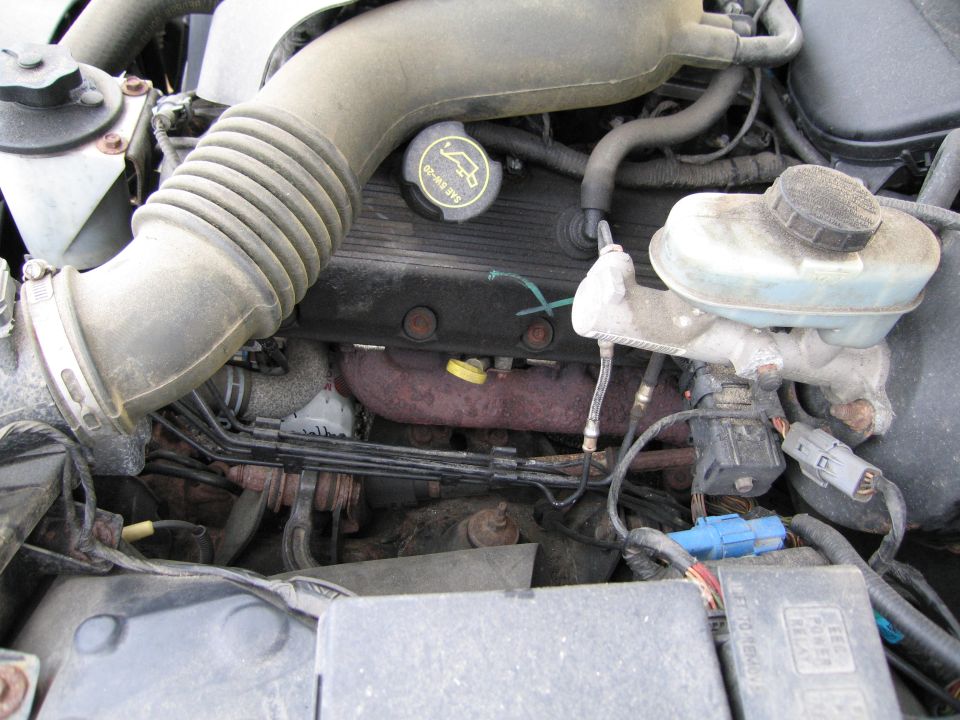 Engine bay detail showing air intake hose, brake fluid reservoir, and engine components