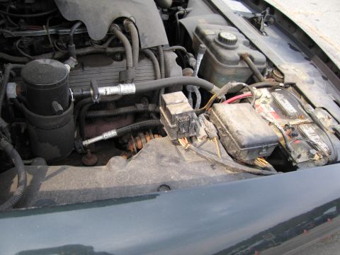 1991 Ford LTD Crown Victoria - Close-up view of the engine compartment, showing the battery and associated wiring.