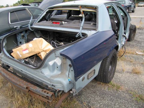 1991 Ford LTD Crown Victoria - This sedan, likely a 1990 model, is in a state of disrepair with its trunk open and rear quarter panel missing.