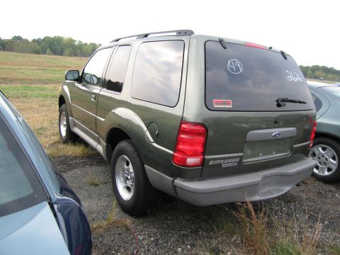 1991 Ford LTD Crown Victoria - This Ford Explorer has an 'Ironman' sticker and a circled '49' on its rear window, parked next to another vehicle.