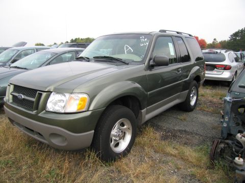 1991 Ford LTD Crown Victoria - Green Ford Explorer in a lot with other vehicles and some parts visible.