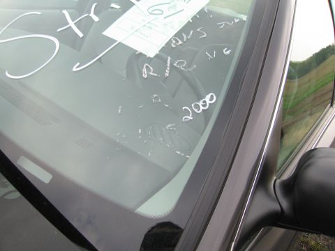 1991 Ford LTD Crown Victoria - Windshield of a car with handwritten notes and a sticker visible on the glass.