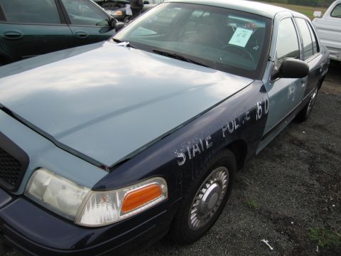 1991 Ford LTD Crown Victoria - A two-tone Ford Crown Victoria, formerly a state police vehicle, is parked outdoors with other vehicles.