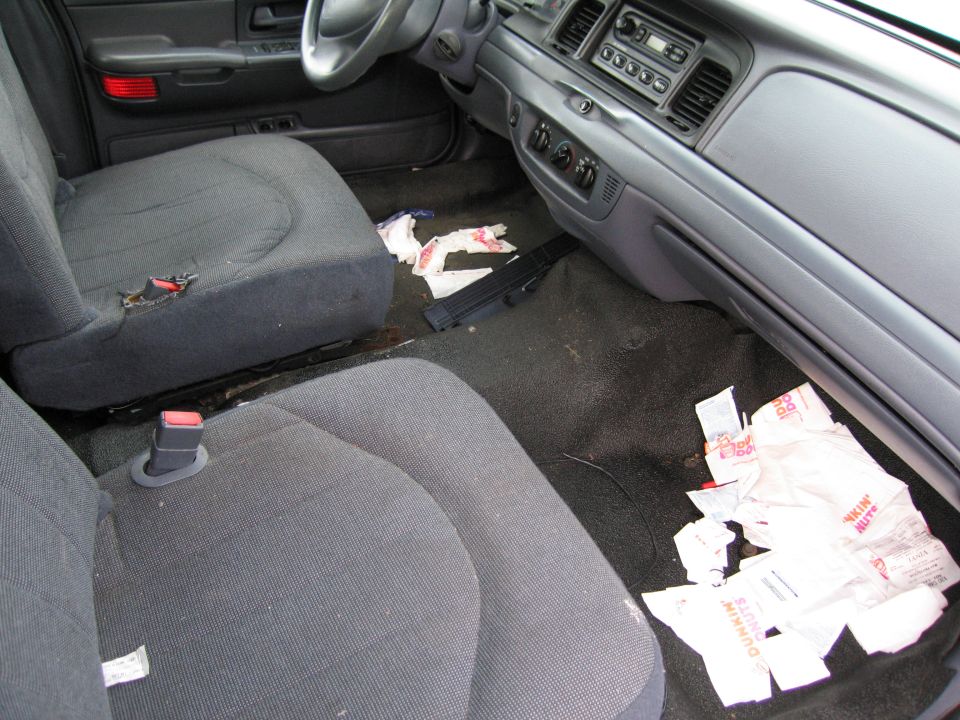 Interior view of a car with Dunkin' Donuts bags on the floor